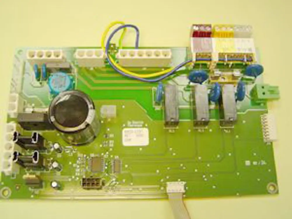 Steuerrelaisplatine von Remeha mit mehreren Relais, Kondensatoren und Anschlüssen für elektrische Verbindungen auf grüner Leiterplatte.